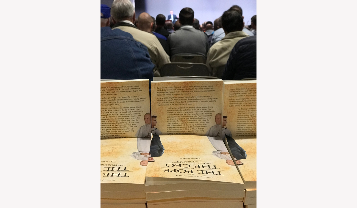 Widmer speaking in background with book in foreground