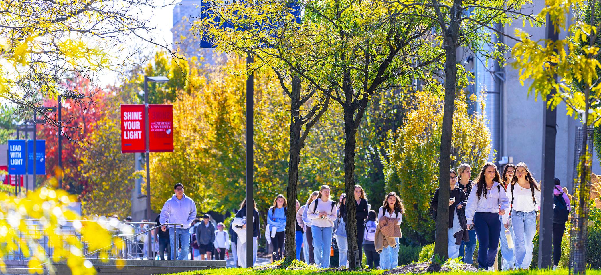 Wide view of campus with student crowds walking.