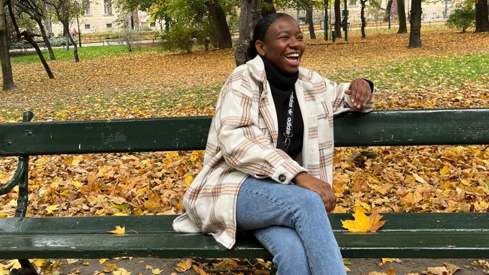 ann laughing at a park with beautiful autumn leaves on the ground