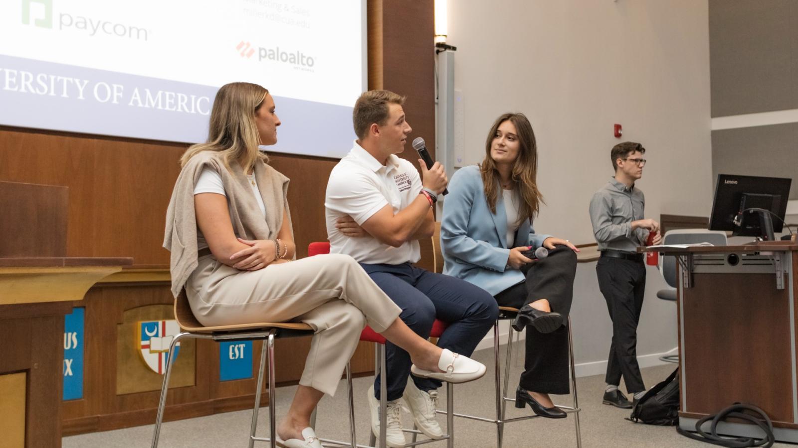 justin speaking on a panel of busch school students