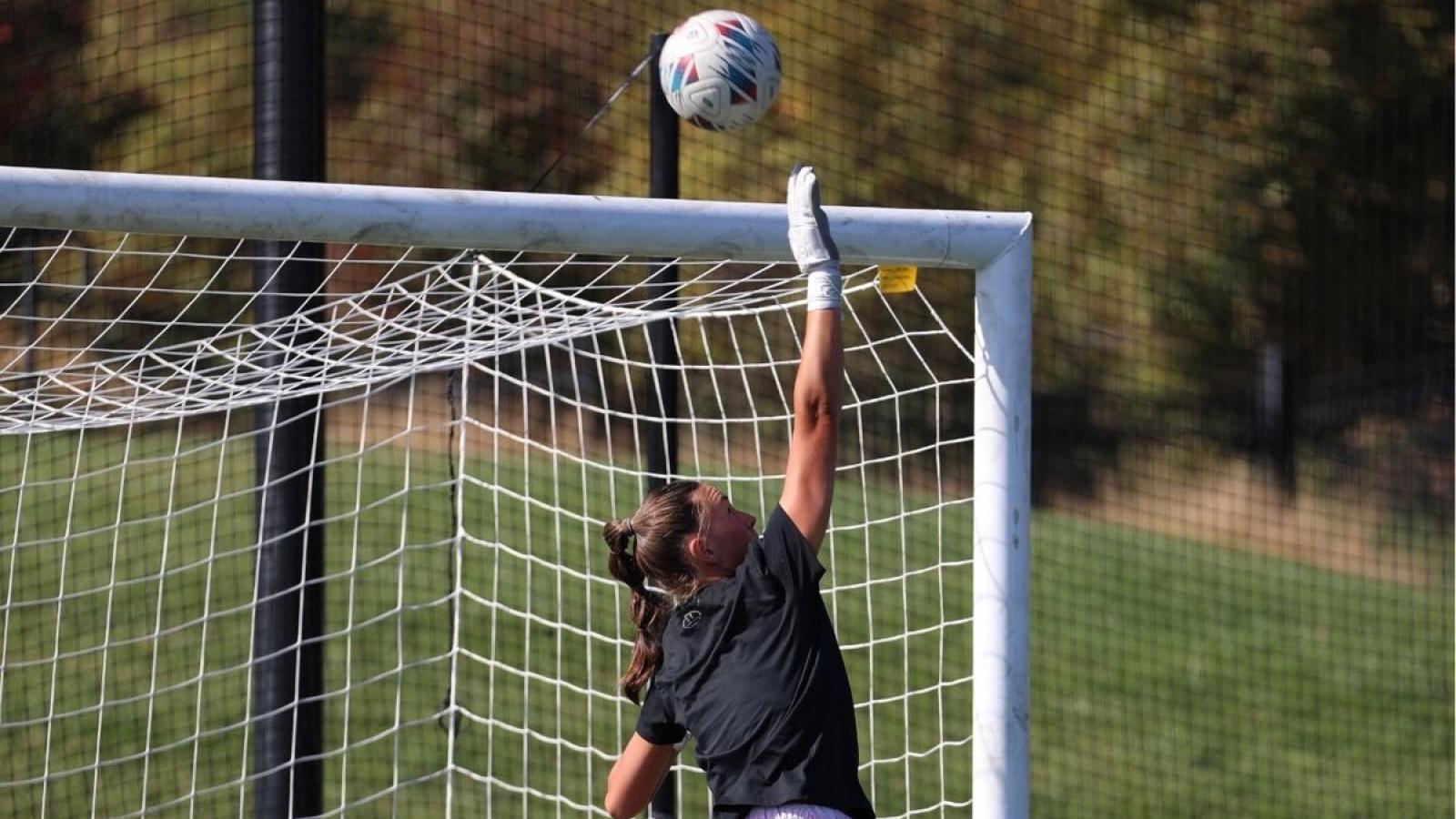 maeve blocking a goal on the cua soccer team