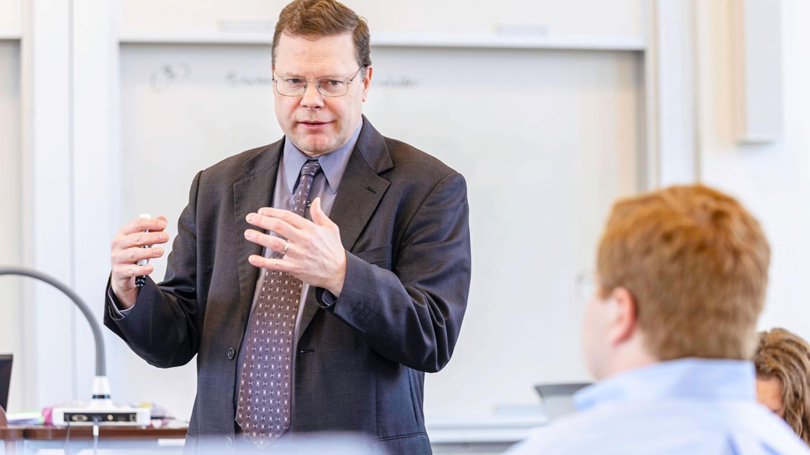Professor discussing business concept with student.