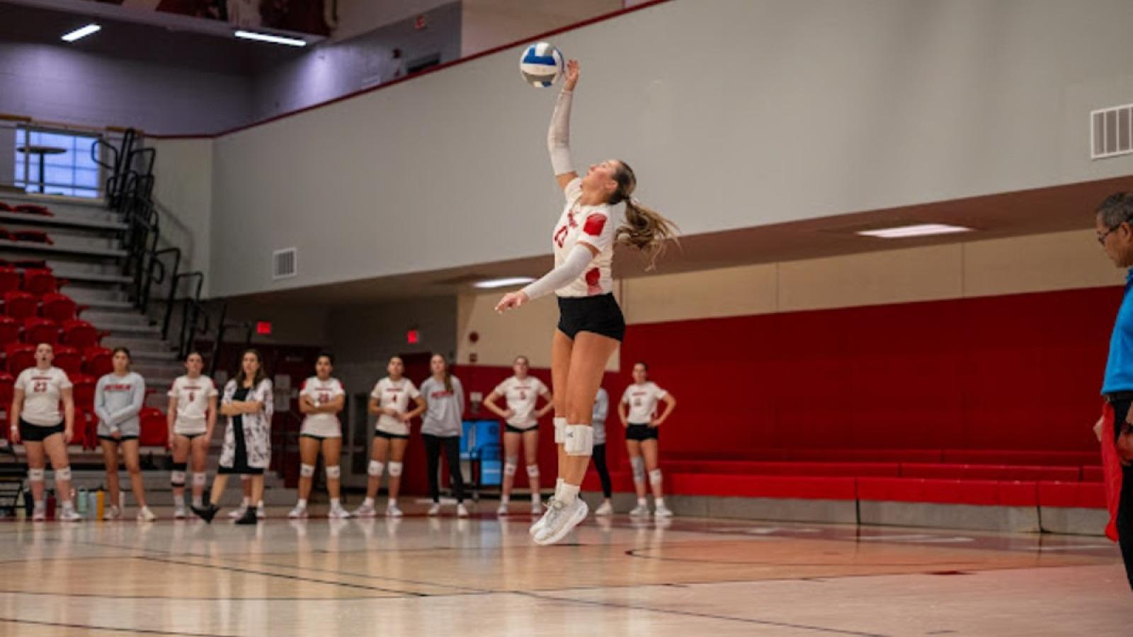 brynne serving during a CUA volleyball game