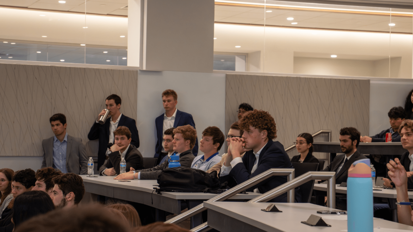 Students are watching a conversation in a classroom.