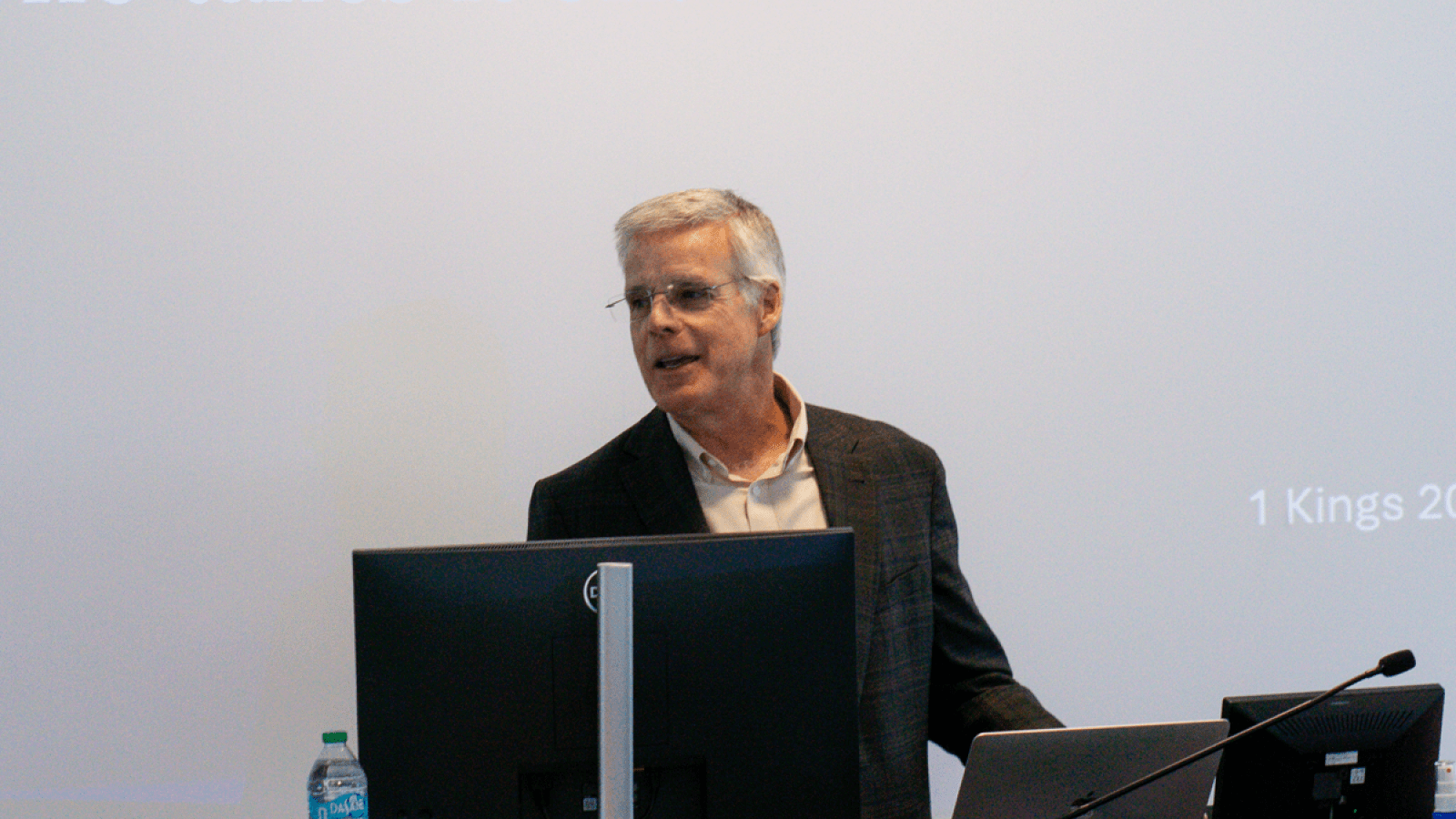 Steve McKee speaking during a lecture in front of a screen and behind a computer.