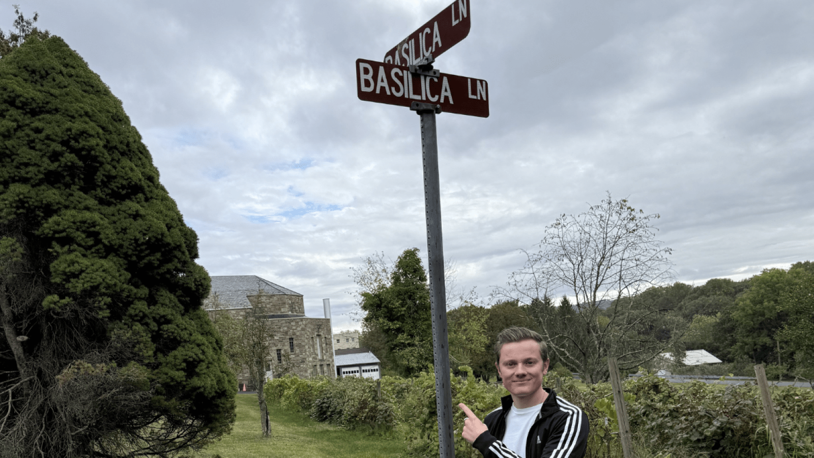 Grady Connolly standing at a street sign of Basilica Lane.
