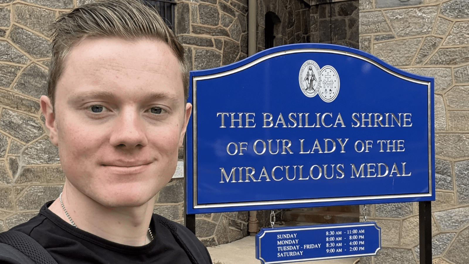 Grady Connolly with the sign for Basilica Shrine of Our Lady of the Miraculous Medal. 