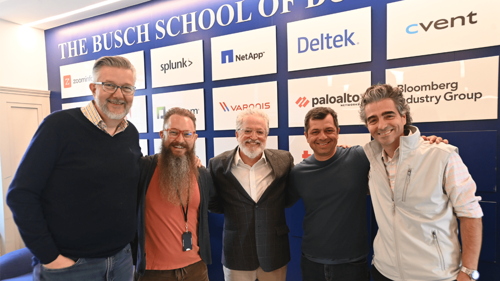 Professors standing in front of the sign for the Hackathon.