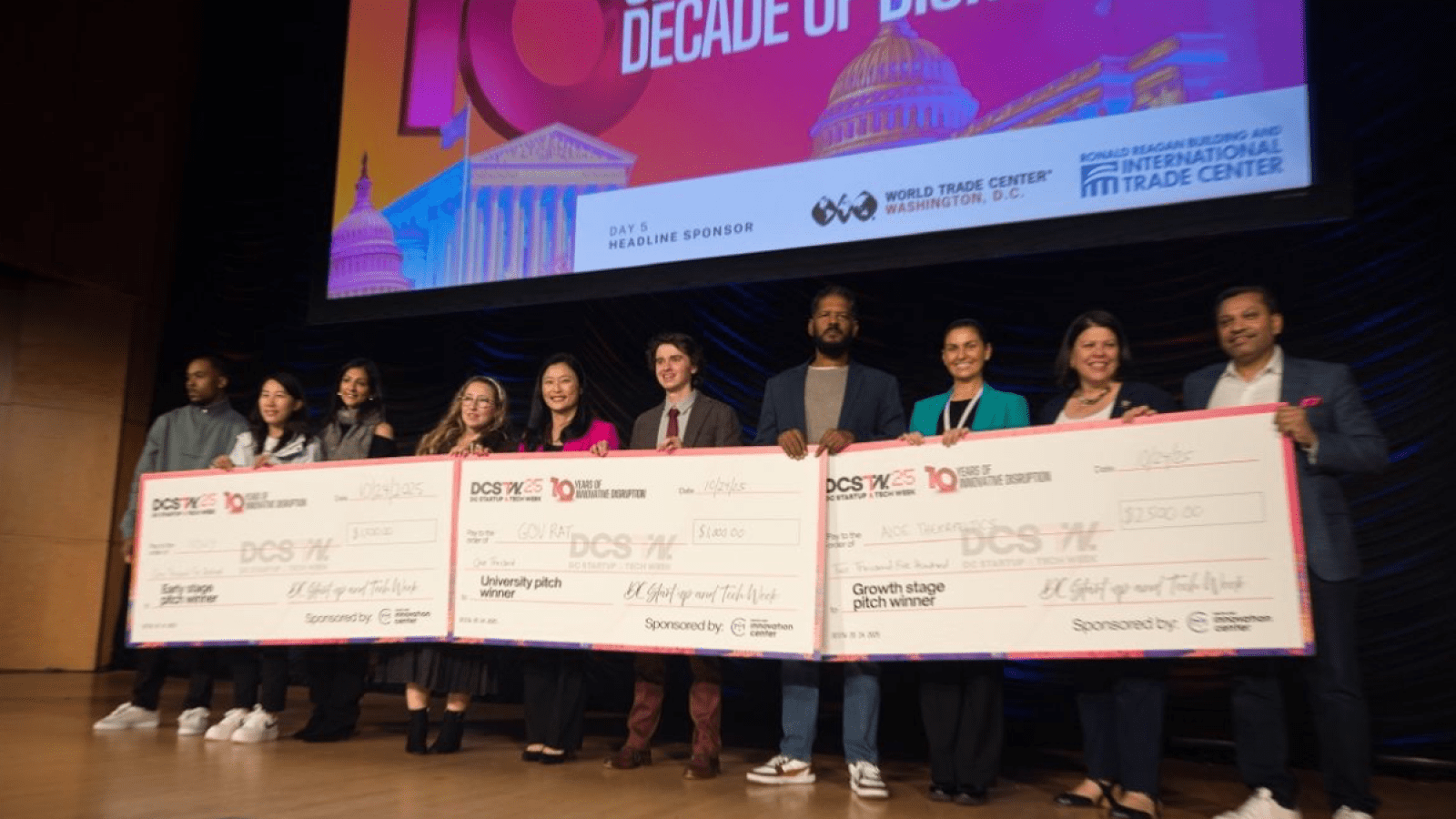 The winners of the Pitch competition with their checks on the stage. 