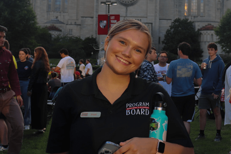 brigid at a Program Board event on campus wearing a program board polo