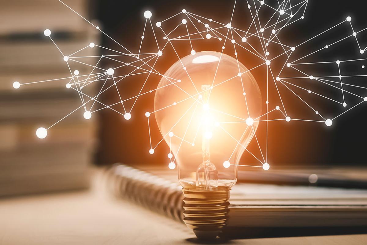Lightbulb with knowledge spark network stretching out.