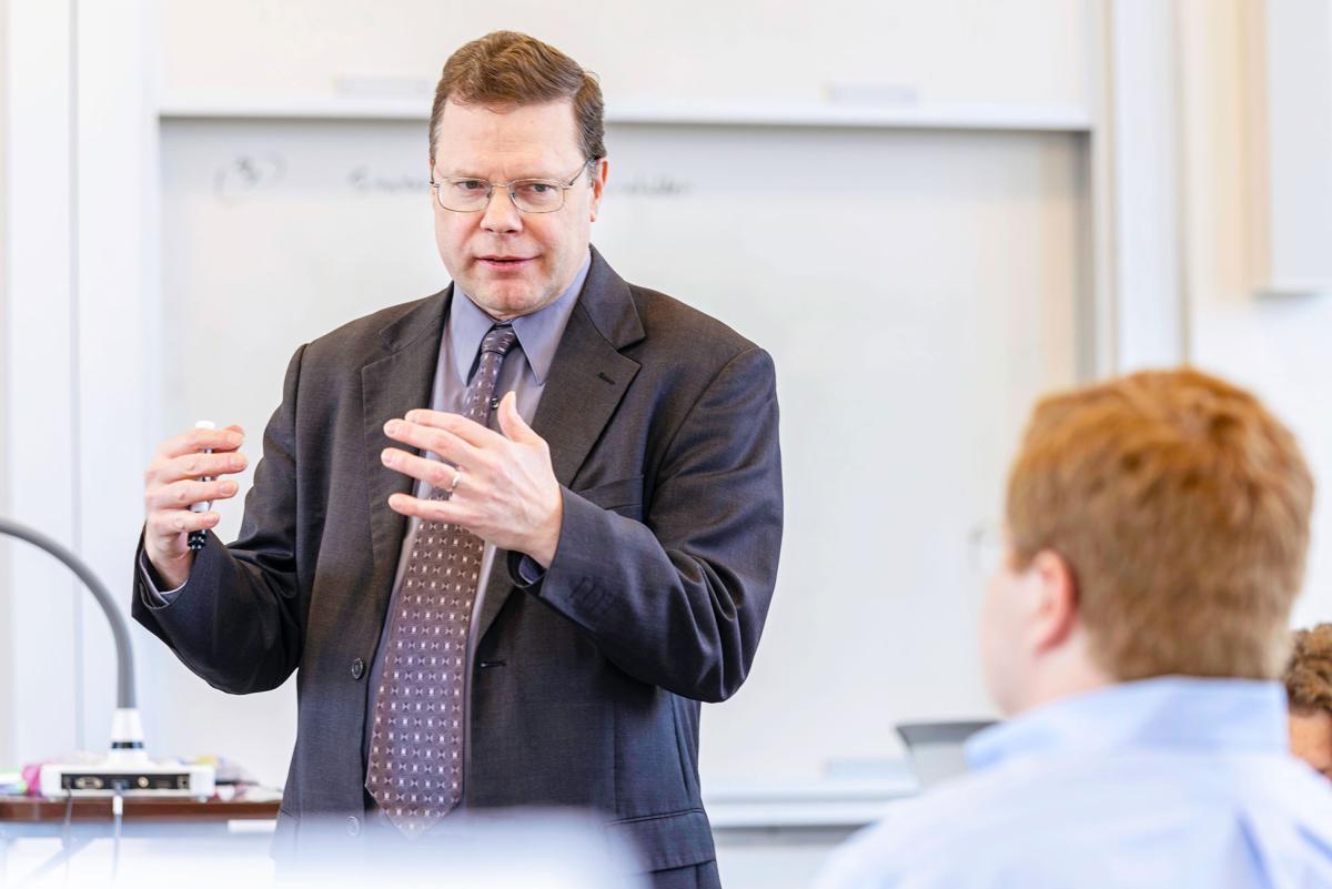 Professor discussing business concept with student.