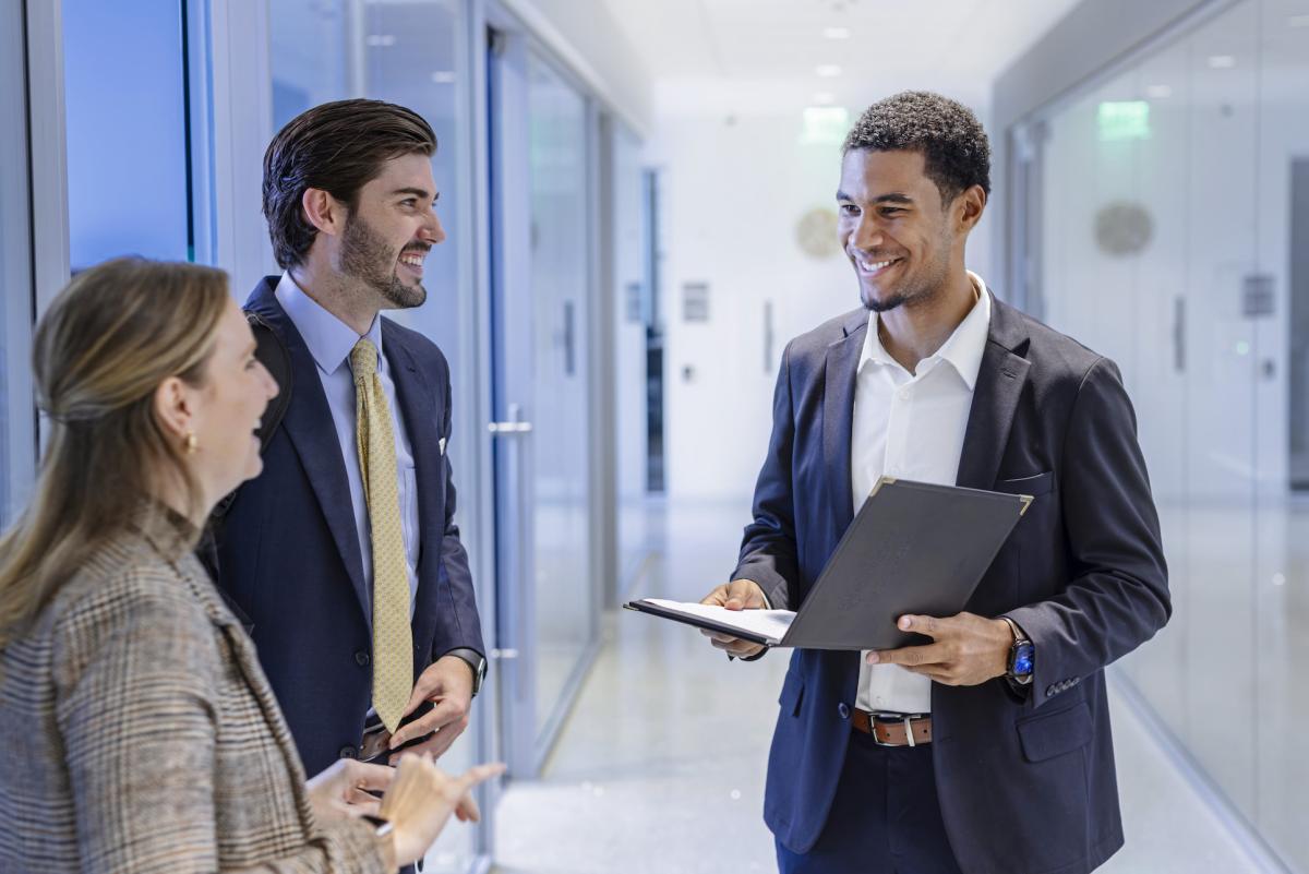 students dressed professionally talking to each other in maloney hall