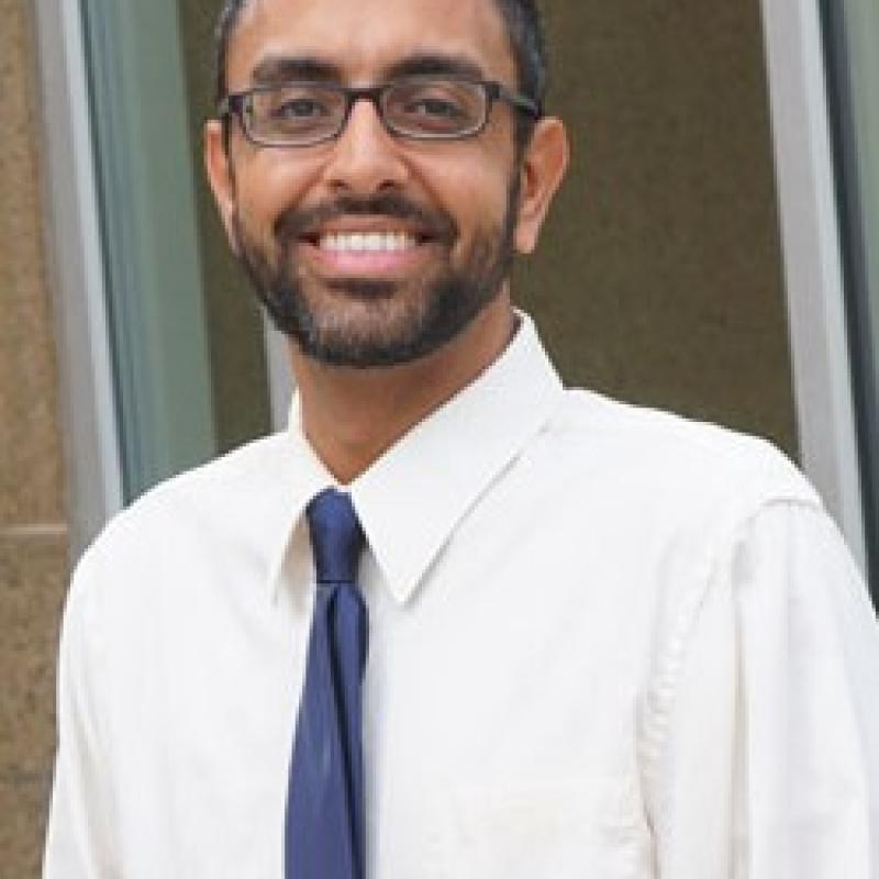 Photo of Robert Felix. He has short dark hair, thin glasses, and is wearing a white shirt with a blue tie.