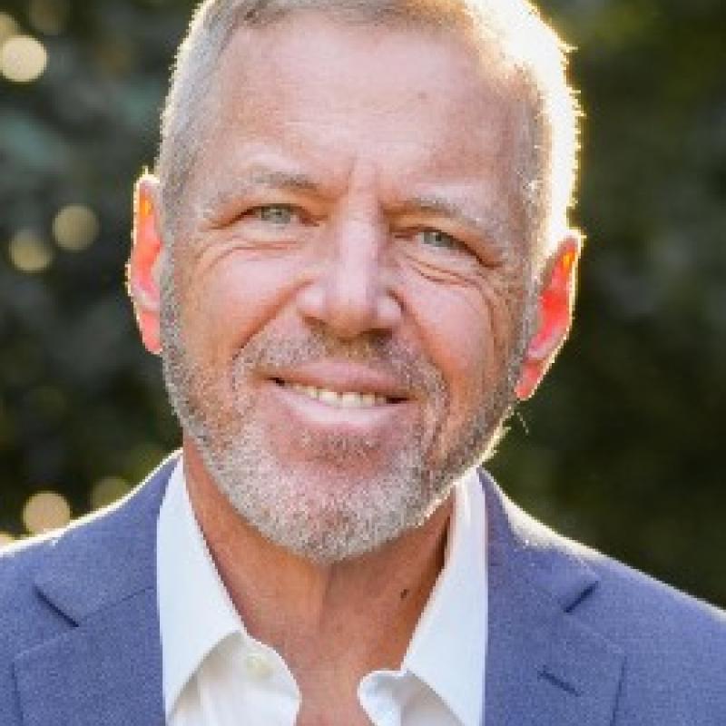 Photo of Michael Pakaluk. He has short grey hair. He is wearing a light blue suit and a white shirt.