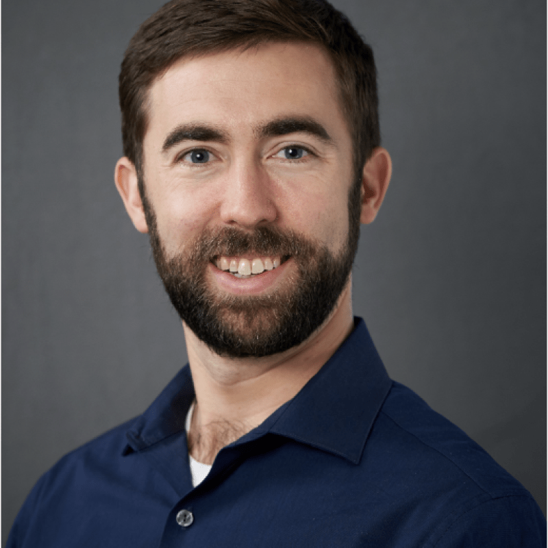 Photo of Richard Gallenstein. He is wearing a navy blue button down shirt and has a brown beard.