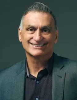 Photo of Deacon Rich Napoli. He has short salt-and-pepper hair. He is wearing a grey suit and a black shirt.