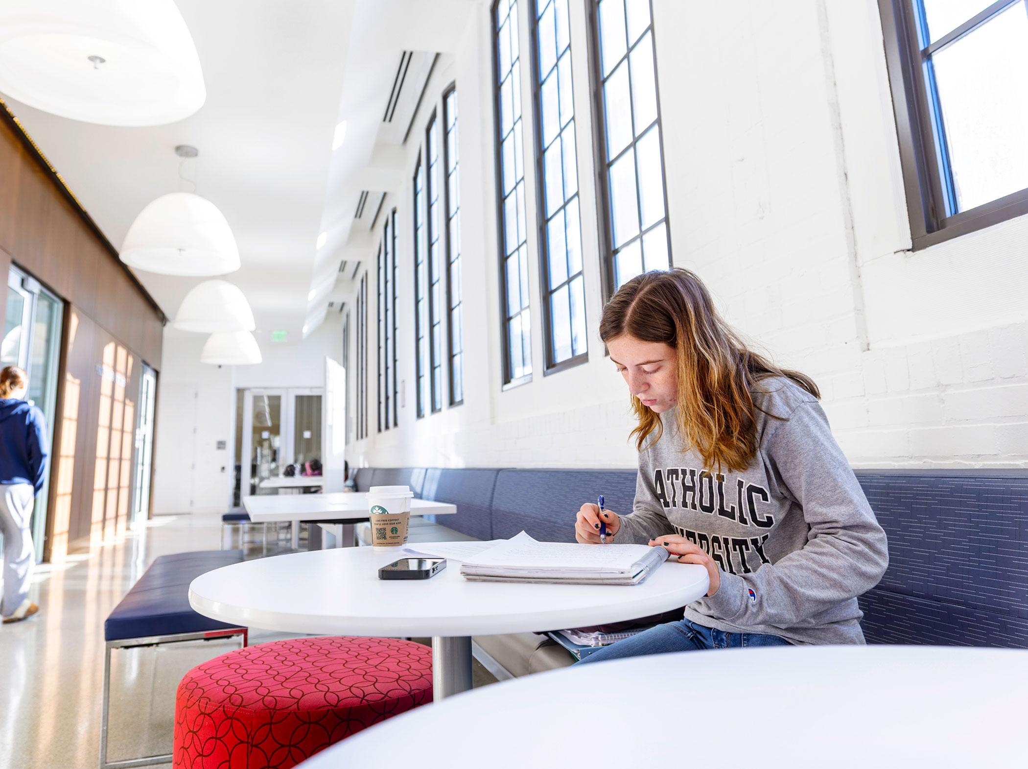 Student studying in Maloney hallway.
